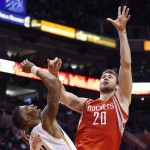 Houston Rockets' Donatas Motiejunas (20), of Lithuania, gets a shot off over Phoenix Suns' Markieff Morris (11) during the first half of an NBA basketball game Tuesday, Feb. 10, 2015, in Phoenix. (AP Photo/Ross D. Franklin)