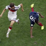 Germany's Thomas Mueller runs with the ball as France's Patrice Evra falls down during the World Cup quarterfinal soccer match at the Maracana Stadium in Rio de Janeiro, Brazil, Friday, July 4, 2014. (AP Photo/Matt Dunham, pool)