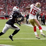 San Francisco 49ers wide receiver Michael Crabtree (15) scores a touchdown as Arizona Cardinals cornerback Jerraud Powers (25) defends during the first half of an NFL football game, Sunday, Sept. 21, 2014, in Glendale, Ariz. (AP Photo/Ross D. Franklin)