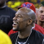 Boxer Floyd Mayweather Jr., right, smiles during halftime of Game 1 of basketball's NBA Finals between the Golden State Warriors and the Cleveland Cavaliers in Oakland, Calif., Thursday, June 4, 2015. (AP Photo/Ben Margot)