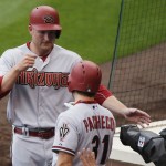 Arizona Diamondbacks right fielder Mark Trumbo, back, is congratulated by catcher Jordan Pacheco after Trumbo scored on an RBI-single hit by Yasmany Tomas against the Colorado Rockies in the fourth inning of the first game of a baseball doubleheader Wednesday, May 6, 2015, in Denver. (AP Photo/David Zalubowski)