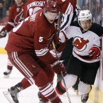 Arizona Coyotes' Connor Murphy (5) gains control of the puck as Coyotes' Lauri Korpikoski, back left, of Finland, checks New Jersey Devils' Tuomo Ruutu (15), of Finland, into the boards during the first period of an NHL hockey game Saturday, March 14, 2015, in Glendale, Ariz. (AP Photo/Ross D. Franklin)