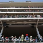 Fans watch a race before the 141st running of the Kentucky Oaks horse race at Churchill Downs Friday, May 1, 2015, in Louisville, Ky. (AP Photo/Jeff Roberson)