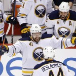 Buffalo Sabres' Andrej Meszaros (41), of the Czech Republic, smiles as he celebrates his second goal of the night with teammate Nicolas Deslauriers (44) as Sabres' Mike Weber (6) shouts from the bench during the second period of an NHL hockey game against the Arizona Coyotes, Monday, March 30, 2015, in Glendale, Ariz. (AP Photo/Ross D. Franklin)
