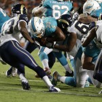 Miami Dolphins running back Daniel Thomas (33) runs for 5 yards for a touchdown as St. Louis Rams defensive tackle Ethan Westbrooks (62) and others defend, during the second half of an NFL preseason football game, Thursday, Aug. 28, 2014, in Miami Gardens, Fla. (AP Photo/Wilfredo Lee)