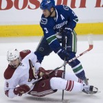 Vancouver Canucks defenseman Kevin Bieksa (3) fights for control of the puck with Arizona Coyotes center Tobias Rieder (8) during the third period of an NHL hockey game Thursday, April 9, 2015, in Vancouver, British Columbia. (AP Photo/The Canadian Press, Jonathan Hayward)
