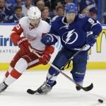 Detroit Red Wings center Riley Sheahan (15) and Tampa Bay Lightning center Tyler Johnson (9) battle for a loose puck during the first period of Game 5 of a first-round NHL Stanley Cup hockey playoff series Saturday, April 25, 2015, in Tampa, Fla. (AP Photo/Chris O'Meara)