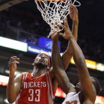 Houston Rockets' Corey Brewer (33) tries to tip the ball in as Phoenix Suns' Eric Bledsoe, right, defends during the first half of an NBA basketball game Tuesday, Feb. 10, 2015, in Phoenix. (AP Photo/Ross D. Franklin)
