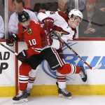 Chicago Blackhawks left wing Patrick Sharp (10) checks Arizona Coyotes defenseman Andrew Campbell against the boards during the first period of an NHL hockey game Monday, Feb. 9, 2015, in Chicago. (AP Photo/Charles Rex Arbogast)