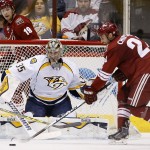 Nashville Predators' Pekka Rinne (35), of Finland, watches the puck as Arizona Coyotes' Kyle Chipchura, right, tries to control the puck to get a shot off during the first period of an NHL hockey game Monday, March 9, 2015, in Glendale, Ariz. (AP Photo/Ross D. Franklin)
