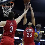 New Orleans Pelicans forward Anthony Davis (23) and center Omer Asik (3) leap for a rebound against Golden State Warriors forward Draymond Green (23) during the first half of Game 3 of a first-round NBA basketball playoff series in New Orleans, Thursday, April 23, 2015. (AP Photo/Gerald Herbert)