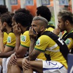 Brazil's Neymar, right, watches from his team's bench during the World Cup third-place soccer match between Brazil and the Netherlands at the Estadio Nacional in Brasilia, Brazil, Saturday, July 12, 2014. (AP Photo/Natacha Pisarenko)