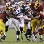 Seattle Seahawks running back Marshawn Lynch (24) is stopped by Washington Redskins defensive end Jarvis Jenkins (99), nose tackle Chris Baker (92) and strong safety Bashaud Breeland (26) during the first half of an NFL football game in Landover, Md., Monday, Oct. 6, 2014. (AP Photo/Patrick Semansky)