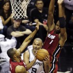 San Antonio Spurs guard Tony Parker (9) is defended by Miami Heat forward Rashard Lewis (9) and center Chris Bosh (1) during the first half in Game 1 of the NBA basketball finals on Thursday, June 5, 2014, in San Antonio. (AP Photo/Tony Gutierrez)