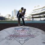 Jeremy Patterson, left, and Courtney Walsh kiss after Patterson proposed to Walsh during batting practice before the San Diego Padres play the Arizona Diamondbacks in a baseball game Thursday, Sept. 4, 2014, in San Diego. (AP Photo/Gregory Bull)