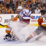 New York Rangers' Daniel Carcillo, center, watches his shot slip past Philadelphia Flyers' Ray Emery, left, for a goal with Andrew MacDonald, left, spaying some ice as he heads toward the goal during the third period in Game 3 of an NHL hockey first-round playoff series, Tuesday, April 22, 2014, in Philadelphia. The Rangers won 4-1. (AP Photo/Chris Szagola)