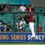 The Arizona Diamondbacks' Mark Trumbo jumps in an attempt to catch a home run ball from Team Australia's Australia's Tim Kennelly during their exhibition baseball game at the Sydney Cricket ground in Sydney, Friday, March 21, 2014. Major League Baseball will open their season Saturday in Sydney with the Los Angeles Dodgers taking on the Diamondbacks. (AP Photo/Rick Rycroft)