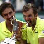French pair Julien Benneteau, right, and Edouard Roger-Vasselin bite their trophy after defeating the Spanish pair Marcel Granollers and Marc Lopez during their men's doubles final match of the French Open tennis tournament at the Roland Garros stadium, in Paris, France, Saturday, June 7, 2014. (AP Photo/Darko Vojinovic)