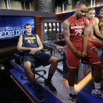 California forward David Kravish, left, sits with Washington State guard DaVonte Lacy (25) and other players while waiting for a group photo session during NCAA college basketball Pac-12 media day in San Francisco, Thursday, Oct. 23, 2014. (AP Photo/Jeff Chiu)