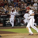 Arizona Diamondbacks' Chris Owings, right, crosses home plate after hitting a home run as San Francisco Giants' Buster Posey, left, watches during the fourth inning of a baseball game Friday, July 17, 2015, in Phoenix. (AP Photo/Ross D. Franklin)
