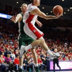 Arizona guard T.J. McConnell (4) shoots in front of Utah Valley forward Brenden Evans (20) during the second half of an NCAA college basketball game, Tuesday, Dec. 9, 2014, in Tucson, Ariz. (AP Photo/Rick Scuteri)
