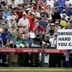 Actor Will Ferrell holds up a sign as he plays the Chicago Cubs third base coach during a spring training baseball exhibition game against the Los Angeles Angels in Tempe, Ariz., on Thursday, March 12, 2015. The comedian plans to play every position while making appearances at five Arizona spring training games on Thursday. (AP Photo/Chris Carlson)