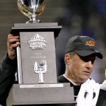Oklahoma State head coach Mike Gundy holds the champion trophy after the Cactus Bowl NCAA college football game against Washington, Friday, Jan. 2, 2015, in Tempe, Ariz. Oklahoma State won 30-22. (AP Photo/Matt York)
