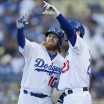 Los Angeles Dodgers' Justin Turner, left, celebrates his solo home run by pretending to take a selfie cell phone photo with teammate Adrian Gonzalez, right, as he comes into the dugout against the Arizona Diamondbacks during the first inning of a baseball game, Saturday, May 2, 2015, in Los Angeles. (AP Photo/Danny Moloshok)