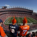 In an image made with a fisheye lens, fans watch the Arizona Cardinals and the Denver Broncos compete during the first half of an NFL football game, Sunday, Oct. 5, 2014, in Denver. (AP Photo/David Zalubowski)