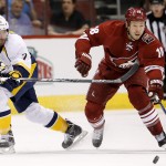 Arizona Coyotes' David Moss (18) tries to gain control of the puck as he gets hit with the stick by Nashville Predators' Matt Cullen (7) during the first period of an NHL hockey game Monday, March 9, 2015, in Glendale, Ariz. (AP Photo/Ross D. Franklin)
