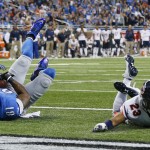 Detroit Lions wide receiver Calvin Johnson (81), defended by Chicago Bears cornerback Kyle Fuller (23), falls into the end zone for a 25-yard reception for a touchdown during the first half of an NFL football game in Detroit, Thursday, Nov. 27, 2014. (AP Photo/Rick Osentoski)