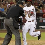  After he scored a run, Arizona Diamondbacks' Didi Gregorius, right, collides with umpire Marty Foster during the sixth inning of a baseball game against the Houston Astros on Monday, June 9, 2014, in Phoenix. (AP Photo/Ross D. Franklin)