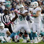 Miami Dolphins defensive end Cameron Wake (91) celebrates after forcing Chicago Bears quarterback Jay Cutler (6) to fumble and then recovering the ball during the second half of an NFL football game Sunday, Oct. 19, 2014 in Chicago. (AP Photo/Nam Y. Huh)