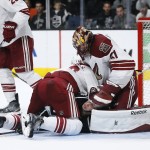 Arizona Coyotes defenseman Oliver Ekman-Larsson, left, jumps on Los Angeles Kings center Nick Shore, center, as he attempts to score past Coyotes goalie Mike Smith, right, during the second period of an NHL hockey game, Monday, March 16, 2015, in Los Angeles. (AP Photo/Danny Moloshok)