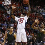Arizona's Rondae Hollis-Jefferson dunks over Oregon's Dillon Brooks, left, and Oregon's Elgin Cook during the second half of an NCAA college basketball game in the championship of the Pac-12 conference tournament Saturday, March 14, 2015, in Las Vegas. Arizona won 80-52. (AP Photo/John Locher)