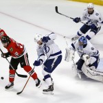 Chicago Blackhawks' Brandon Saad (20) tries to get his stick on the puck as Tampa Bay Lightning's Andrej Sustr, of the Czech Republic, goalie Ben Bishop (30) and Tyler Johnson (9) defend during the second period in Game 6 of the NHL hockey Stanley Cup Final series on Monday, June 15, 2015, in Chicago. (AP Photo/Charles Rex Arbogast)
