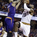 Phoenix Suns' Markieff Morris, left, fouls Cleveland Cavaliers' LeBron James during the second quarter of an NBA basketball game Saturday, March 7, 2015, in Cleveland. (AP Photo/Tony Dejak)