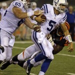 Indianapolis Colts quarterback Chandler Harnish (5) is sacked by Cincinnati Bengals defensive end Sam Montgomery (70) in the second half of an NFL preseason football game, Thursday, Aug. 28, 2014, in Cincinnati. Colts offensive guard Thomas Austin pursues. (AP Photo/Tom Uhlman)