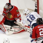 Chicago Blackhawks goalie Corey Crawford, left, stops a shot from Tampa Bay Lightning's Ondrej Palat, of the Czech Republic, as Blackhawks' Duncan Keith (2) watches during the third period in Game 6 of the NHL hockey Stanley Cup Final series on Monday, June 15, 2015, in Chicago. (AP Photo/Charles Rex Arbogast)
