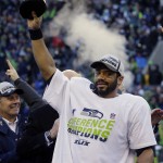 Seattle Seahawks' Russell Wilson holds up the George Halas Trophy after overtime of the NFL football NFC Championship game against the Green Bay Packers Sunday, Jan. 18, 2015, in Seattle. The Seahawks won 28-22 to advance to Super Bowl XLIX. (AP Photo/Ted S. Warren)
