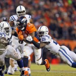 Denver Broncos running back C.J. Anderson (22) converts a fourth down run for a first down as Indianapolis Colts cornerback Vontae Davis (21) and Arthur Jones (97) tackle during the second half of an NFL divisional playoff football game, Sunday, Jan. 11, 2015, in Denver. (AP Photo/Joe Mahoney)
