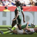 United States' Becky Sauerbrunn, bottom, tackles Nigeria's Courtney Dike during the first half of a FIFA Women's World Cup soccer game Tuesday, June 16, 2105, in Vancouver, British Columbia, Canada. (Darryl Dyck/The Canadian Press via AP)