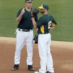 Actor Will Ferrell, left, talks it over with Oakland Athletics second baseman Andy Parrino during the first inning of a spring training baseball game against the Seattle Mariners, Thursday, March 12, 2015, in Mesa, Ariz. The comedian plans to play every position while making appearances at five Arizona spring training games on Thursday. (AP Photo/Matt York)