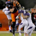 Oklahoma State fullback Jeremy Seaton pulls in a pass as Washington's John Ross, rear, and Budda Baker, middle, and John Timu, right, defend during the second half of the Cactus Bowl NCAA college football game, Friday, Jan. 2, 2015, in Tempe, Ariz. (AP Photo/Rick Scuteri)