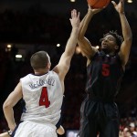 Stanford guard Chasson Randle (5) shoots over Arizona guard T.J. McConnell during the first half of an NCAA college basketball game, Saturday, March 7, 2015, in Tucson, Ariz. (AP Photo/Rick Scuteri)