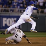 Kansas City Royals' Alcides Escobar leaps over San Francisco Giants' Joe Panik (12) as Buster Posey hit into a double play during the third inning of Game 6 of baseball's World Series Tuesday, Oct. 28, 2014, in Kansas City, Mo. (AP Photo/Charlie Neibergall)