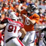 Denver Broncos quarterback Peyton Manning (18) throws under pressure from Arizona Cardinals outside linebacker Matt Shaughnessy (91) during the first half of an NFL football game, Sunday, Oct. 5, 2014, in Denver. (AP Photo/Jack Dempsey)