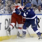 Tampa Bay Lightning center Tyler Johnson (9) checks Detroit Red Wings right wing Luke Glendening into the boards during the first period of Game 7 of a first-round NHL Stanley Cup hockey playoff series Wednesday, April 29, 2015, in Tampa, Fla. (AP Photo/Chris O'Meara)