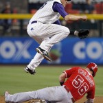 Arizona Diamondbacks' Nick Ahmed, top, jumps over Los Angeles Angels' Kole Calhoun (56) after forcing him out at second base during the first inning of a baseball game Thursday, June 18, 2015, in Phoenix. (AP Photo/Ross D. Franklin)