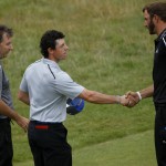 Rory McIlroy of Northern Ireland and Dustin Johnson of the US, second right, shake hands as his caddie JP Fitzgerald, left, and Francesco Molinari of Italy look on after their round on the third day of the British Open Golf championship at the Royal Liverpool golf club, Hoylake, England, Saturday July 19, 2014. (AP Photo/Peter Morrison)